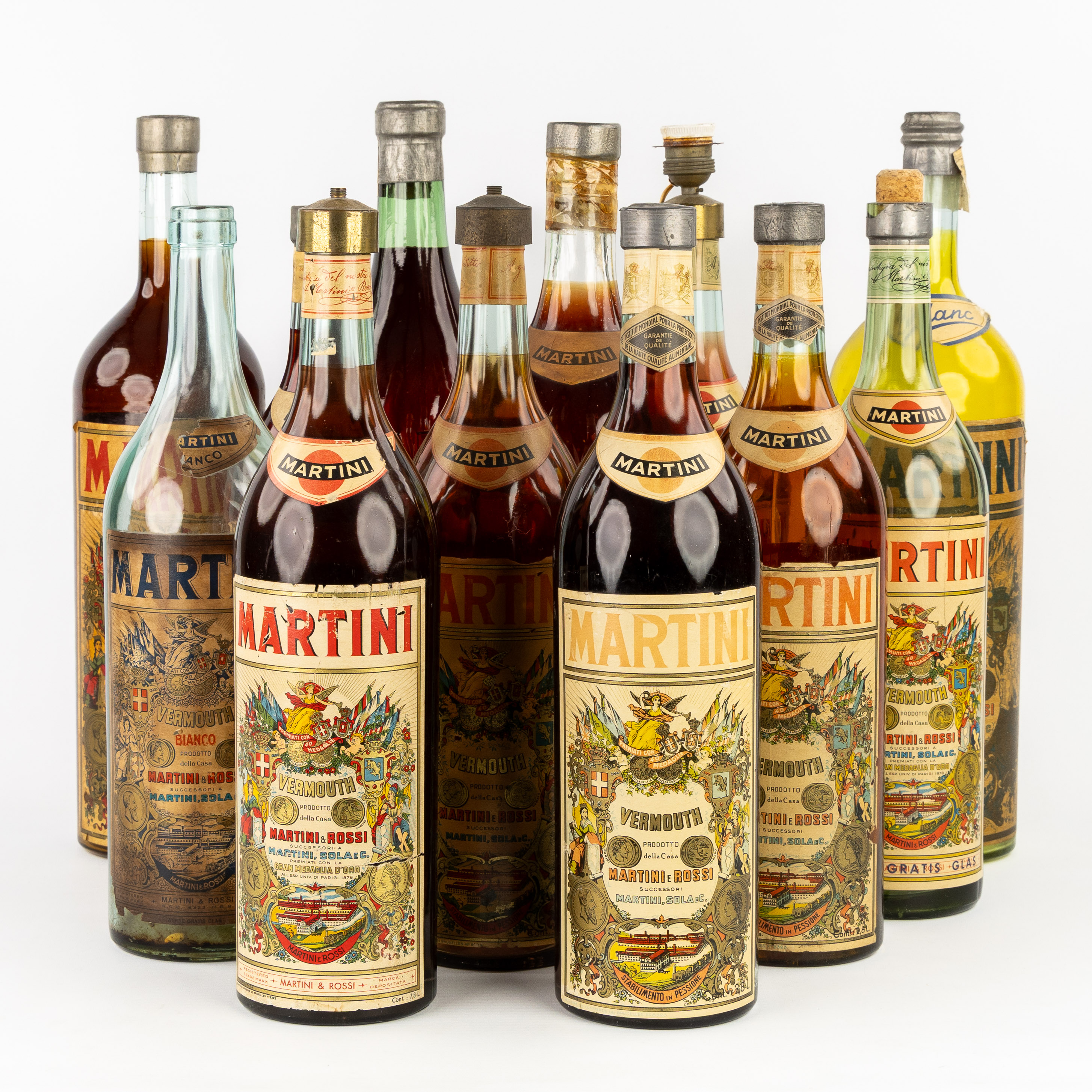 Een collectie van 12 decoratieve Martini Vermouth flessen of factices, grote modellen, circa 1940-1960. (L:16 x H:53.5 cm)